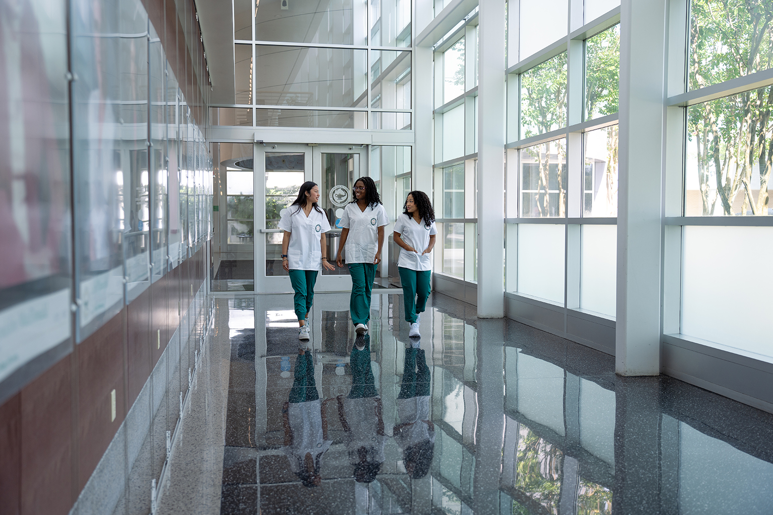 Nursing students walk in the USF Health College of Nursing atrium. 