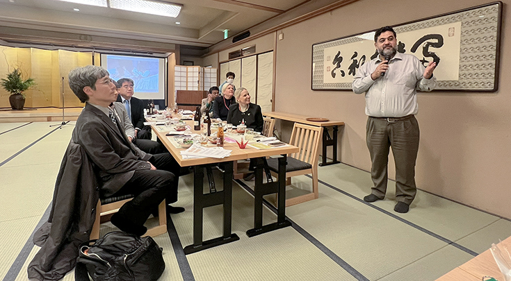 A large conference room in Japan as Jesse Casanova gives a presentation
