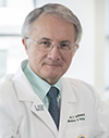 A man in a white coat in a bright room