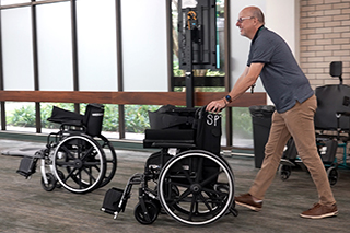 man pushes wheelchairs
