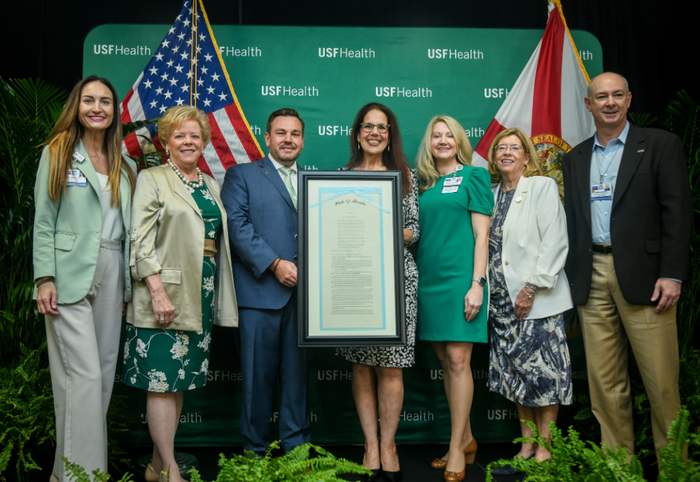 President Law, Representative Anderson, and Dr. Lockwood holding a signed copy of the Sunshine Genetics Act. 