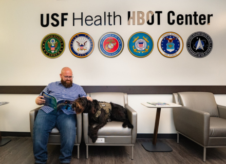 Erik Velasquez in fornt of the USF Health HBOT Center sign