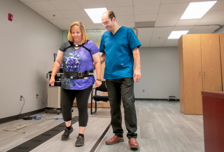 Amir Tabatabeai helping research participant Angela Arroyo through physical therapy exercises