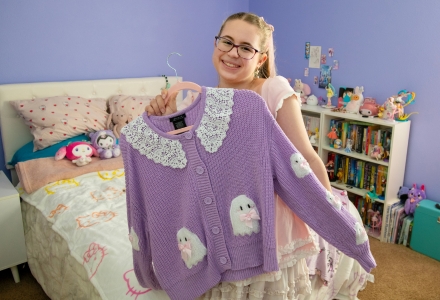 Kaila holding one of her sweaters. 