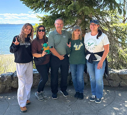 Bob and Karin Johnson (center) with family members holding a plush Rocky the Bull, the USF mascot. 