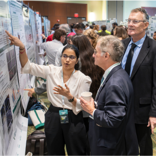conversing in front of a research poster