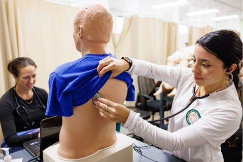 Nursing student listening to manikin's lungs