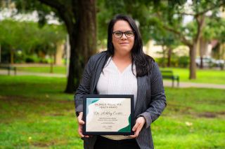 Ashley Curtis, PhD, poses with her Valerie D Riddle, M.D., Award in Health.