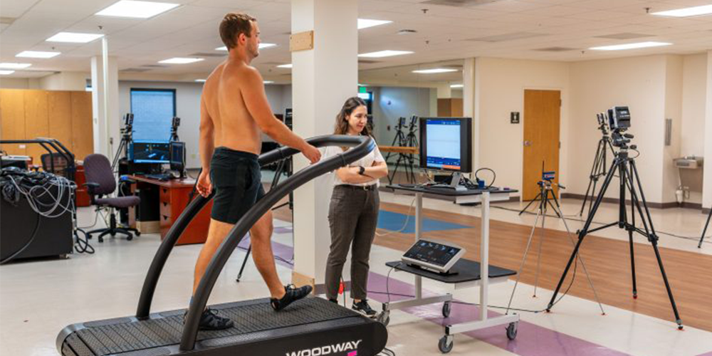 person walking on treadmill while specialist analyzes