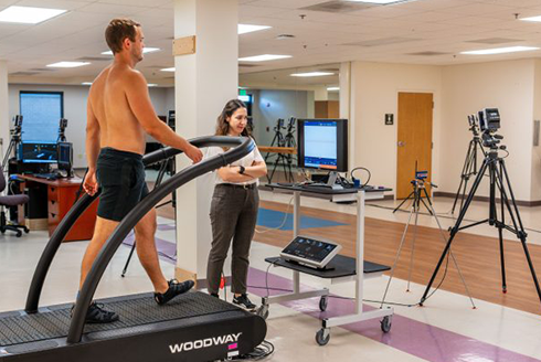 person walking on treadmill while specialist analyzes
