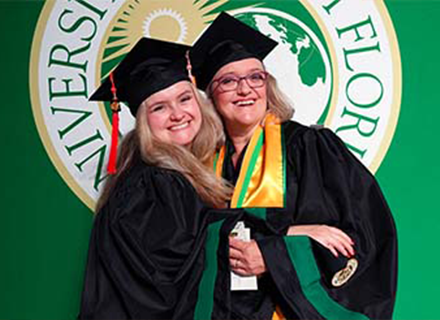 two women posing in graduation attire