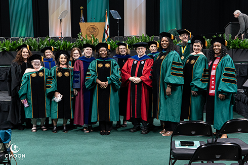 text: graduates dressed in graduation attire