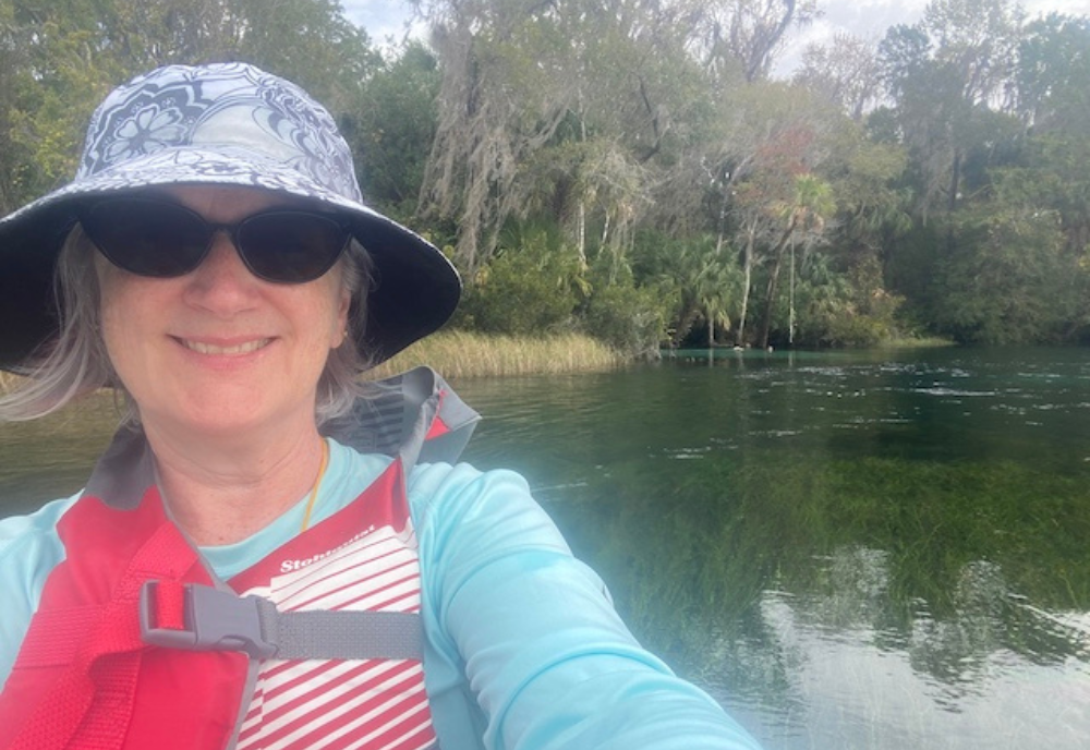 woman with hat and sunglasses on river