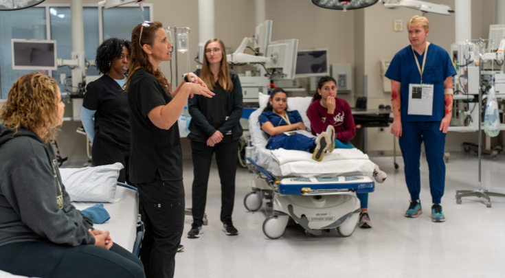 woman teaching students in lab