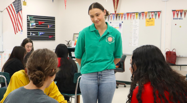 a college aged woman teaching a group of children
