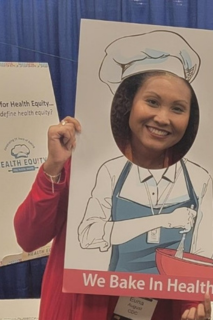 a woman smiling with a sign