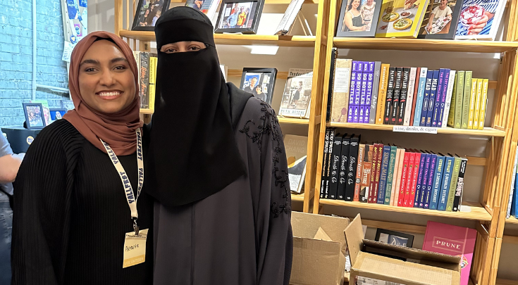 two people posing for a picture with books