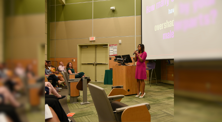 woman speaking in front of audience