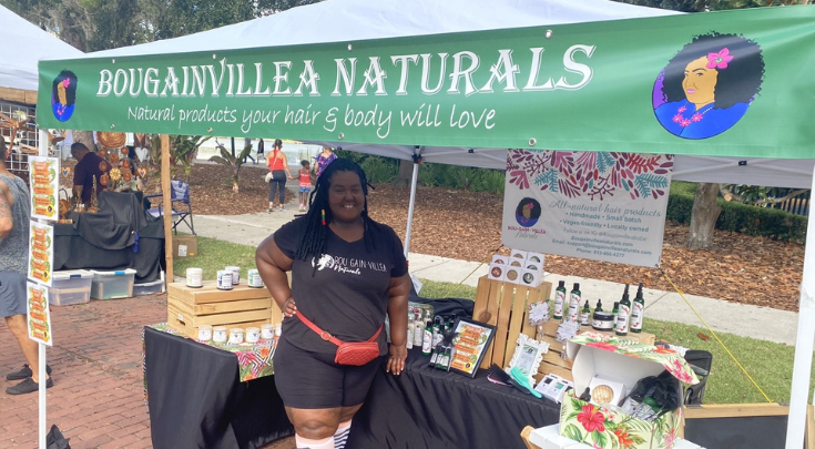 a woman standing at a vendor booth outside