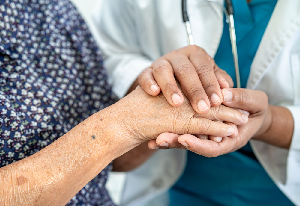 Doctor holding hands with elderly patient