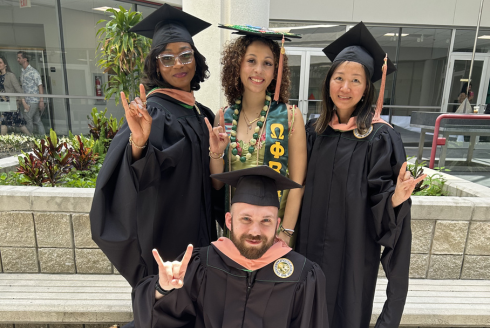 4 graduates in cap and gown