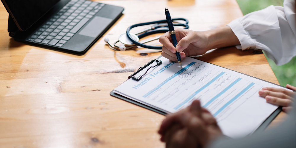 Woman signing health insurance forms.