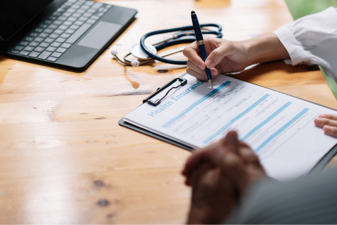 Woman signing health insurance forms.