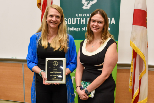 two women being presented with an award