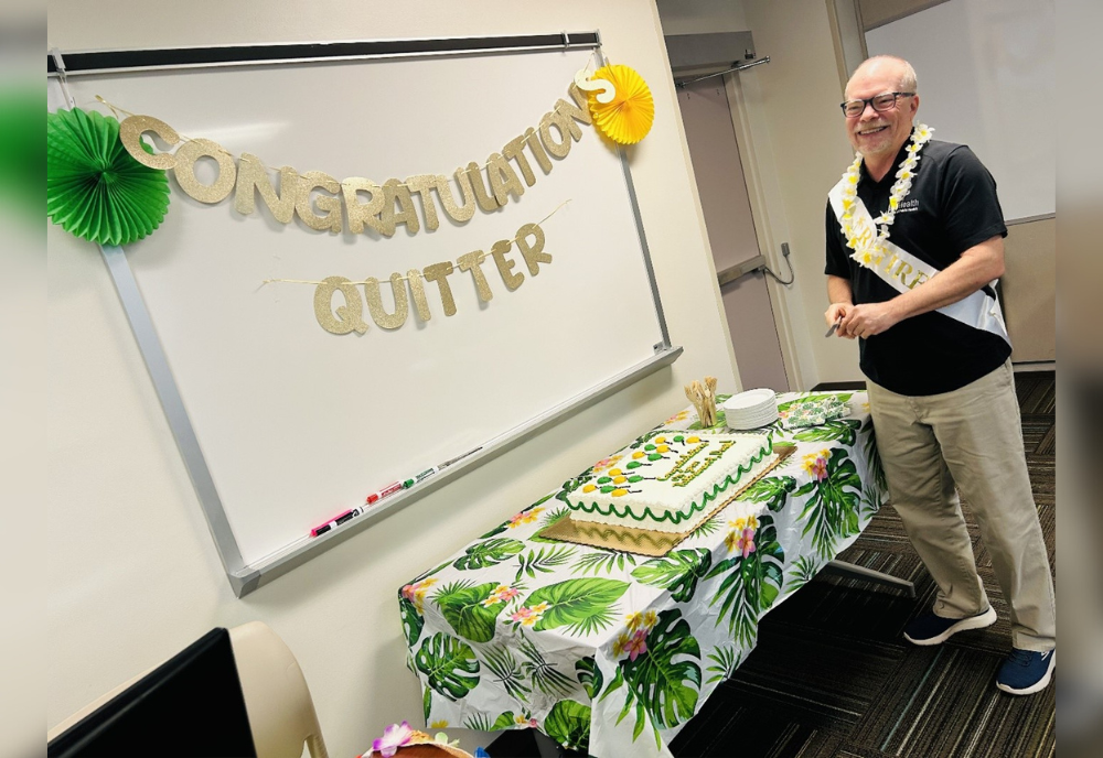 Dave Hogeboom standing in front of his retirement cake. A banner reads "Congrats, quitter!"