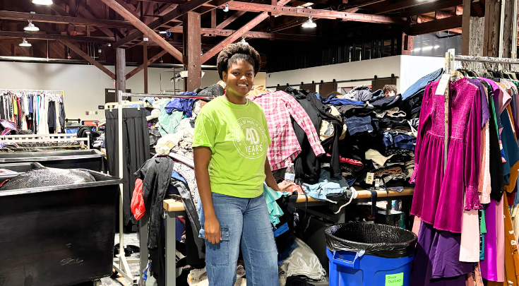 a person smiling in a clothing warehouse