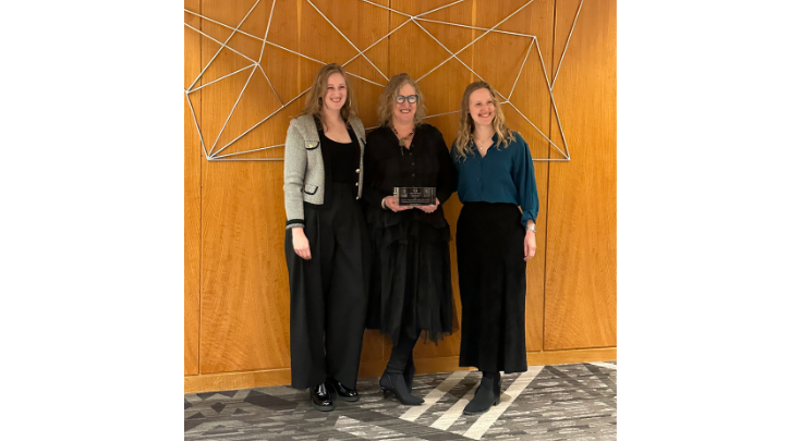 three women holding an award