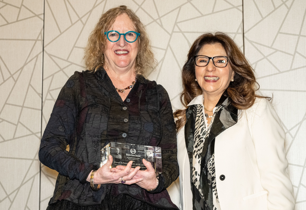two women holding an award