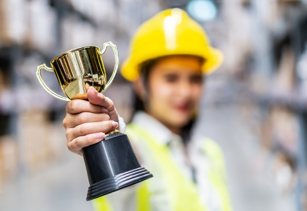 Warehouse worker holding a trophy.