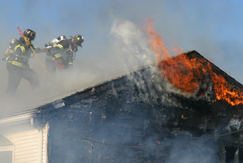 two firemen putting out a fire