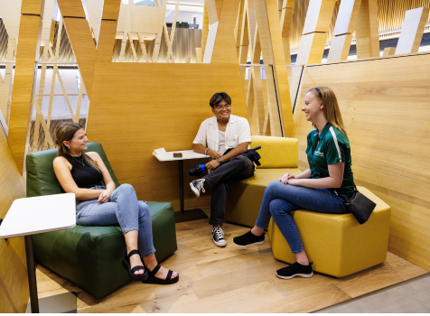 Three honors students sit and chat in a learning loft at the Honors College