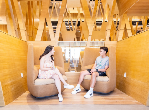 Two Honors students sit and chat in a learning loft at the Honors College