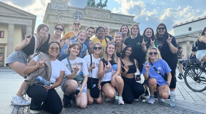 A group of Honors students and their trip leaders pose in front of a historic building in Berlin, Germany.