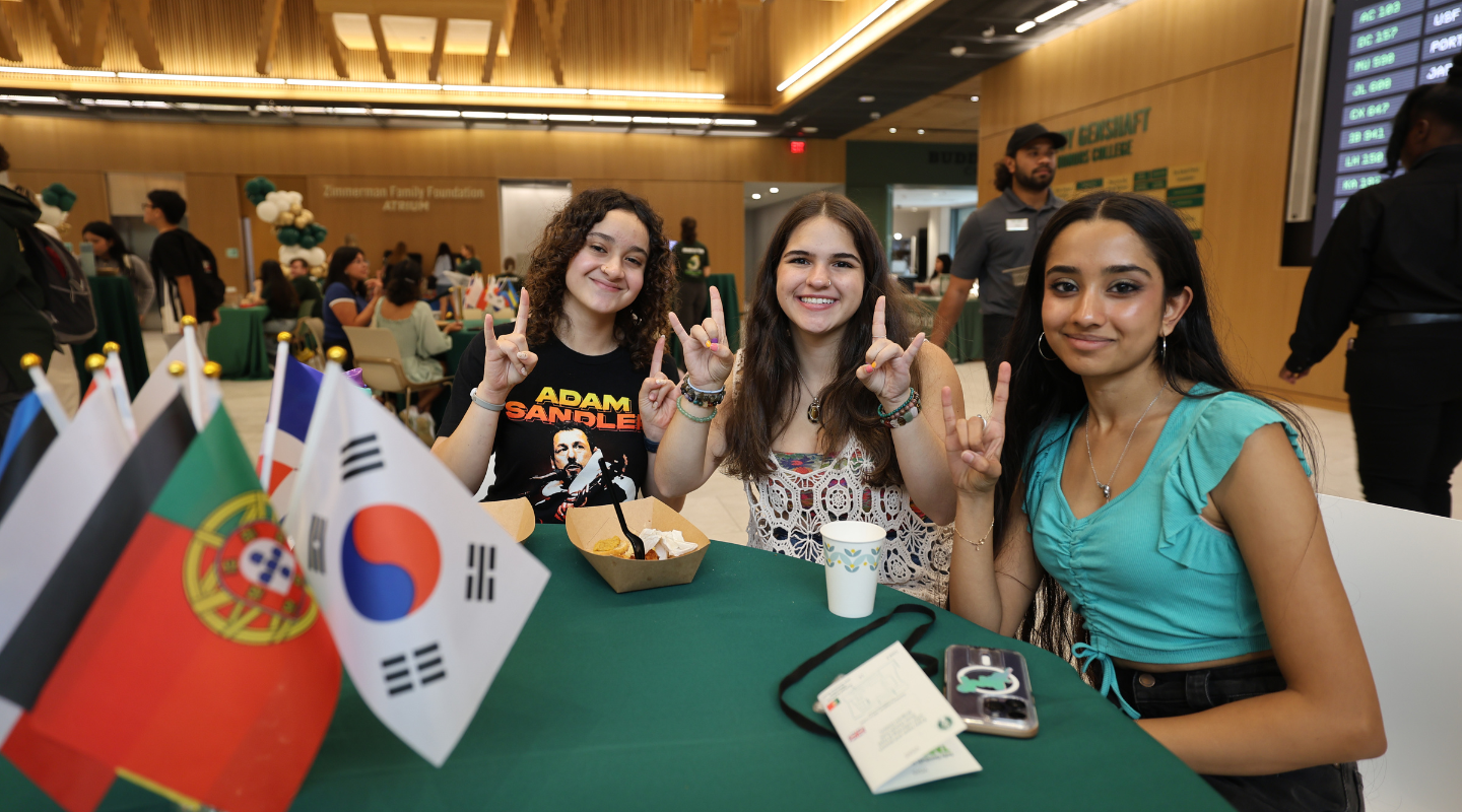 Photo of three students at Tapas Night enjoying a snack.