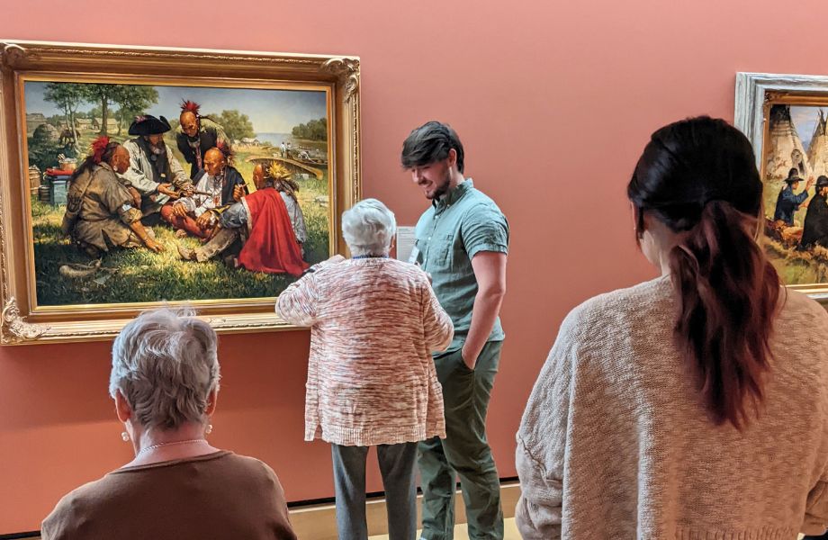 An honors students talks with a member of a community with Alzheimer's/dementia about art in a museum