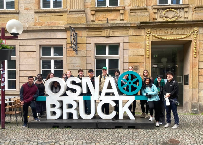 A small group of Honors students posing around the Osnabruck sign in Osnabruck, Germany.
