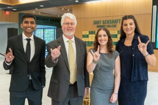 Image linking to the Judy Genshaft Honors Alumni Society webpage, featuring three smiling alumni and Honors Dean Charles Adams
