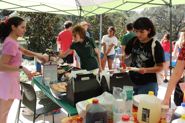 Students and Judy Genshaft stand in line to get food at the 2025 Bull Bash