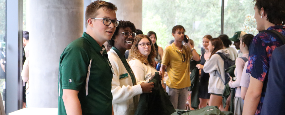 Honors ambassadors and peer mentors hand out shirts to incoming Honors students.