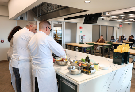 Three chefs cook Italian food for an audience in the food and culture studio
