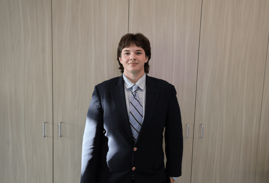 Headshot of David Combs standing in front of a blank background