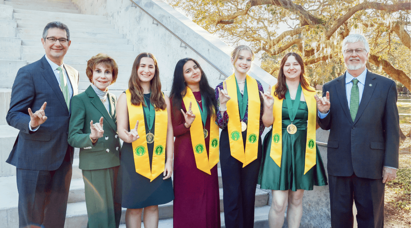 Fall 2025 Dean's Circle of Merit Winners with Dean Adams, Judy Genshaft, and Steve Greenbaum outside the Honors amphitheater.