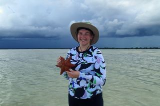 Gabby Schwager holding a starfish in the Barbados ocean