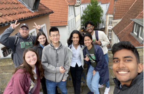 Germany innovation in engineering students smile in front of picturesque rooftops.