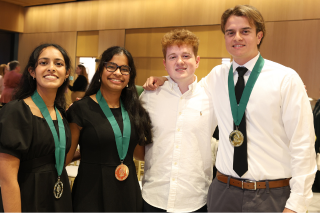 Image linking to the Judy Genshaft Honors graduation webpage, featuring four smiling students, three of which are wearing Judy Genshaft Honors College medallions.