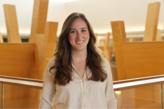 Honors Alum Dr. Bailee Olliff poses in the Judy Genshaft Honors College building.